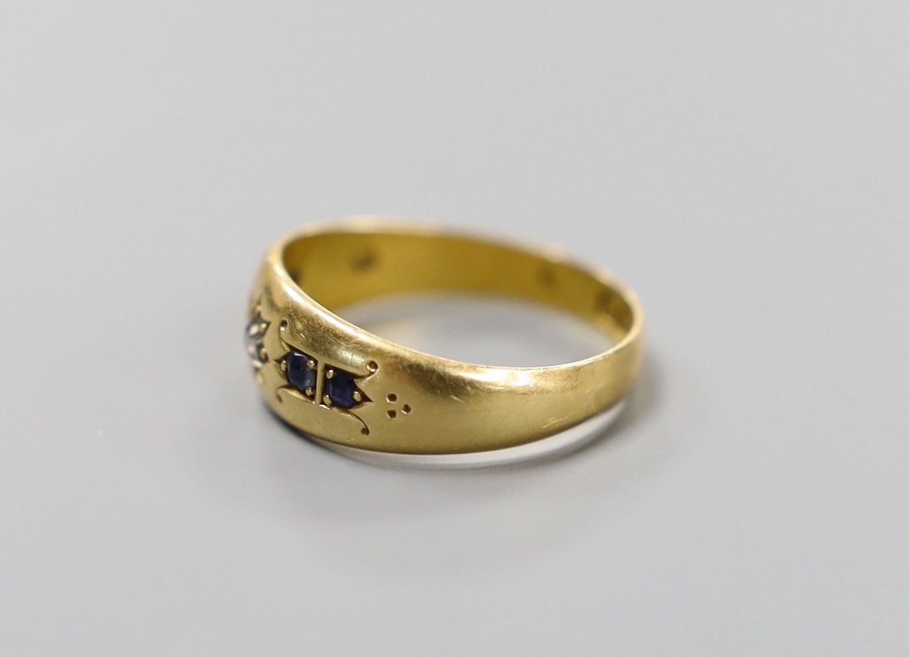 A late Victorian 18ct gold, single stone diamond and four stone sapphire gypsy set ring, size N, gross weight 3.2 grams.